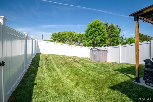 view of yard with an outdoor structure, a fenced backyard, and a storage unit