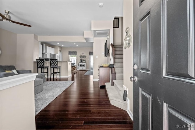 foyer featuring stairs, baseboards, visible vents, and dark wood-type flooring