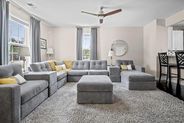 living room with visible vents, a ceiling fan, baseboards, and wood finished floors