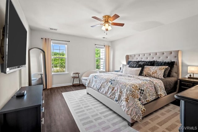 bedroom featuring a ceiling fan, baseboards, visible vents, and wood finished floors