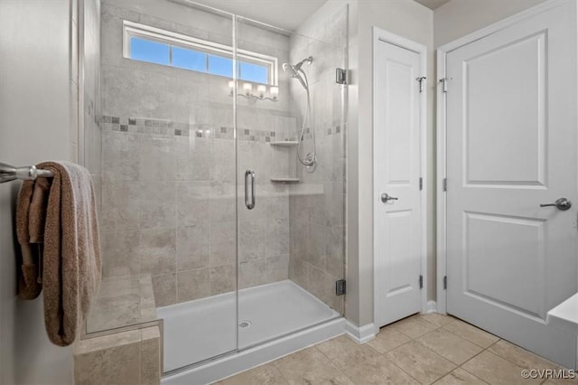 bathroom with a shower stall and tile patterned flooring