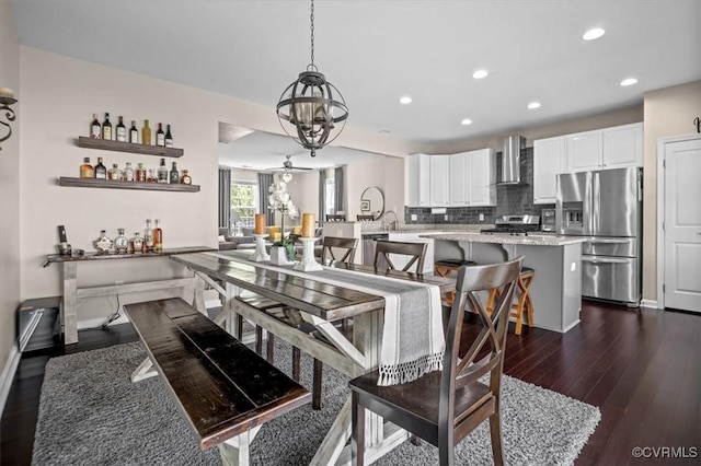 dining room featuring recessed lighting, baseboards, dark wood-style floors, and an inviting chandelier