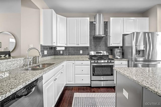 kitchen with wall chimney range hood, appliances with stainless steel finishes, light stone countertops, and a sink