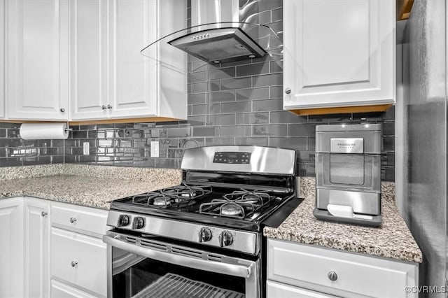 kitchen featuring decorative backsplash, wall chimney exhaust hood, white cabinetry, and stainless steel appliances