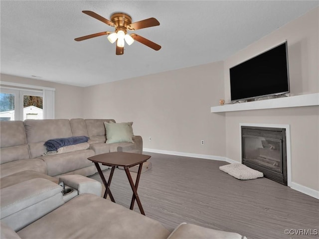 239 Marine Dr, Dunnsville, VA 22454 - living area with baseboards, a ceiling fan, wood finished floors, and a glass covered fireplace