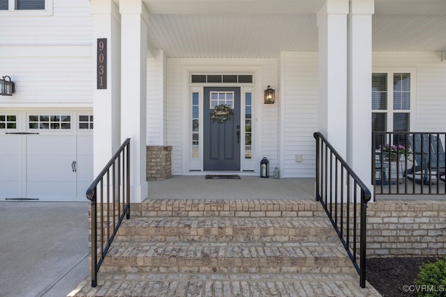 property entrance featuring a garage, covered porch, and stone siding