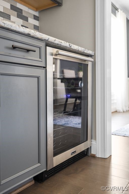 details featuring wine cooler and wood finished floors