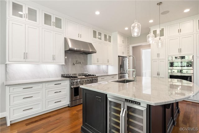 kitchen featuring appliances with stainless steel finishes, white cabinetry, wine cooler, under cabinet range hood, and dark wood-style floors