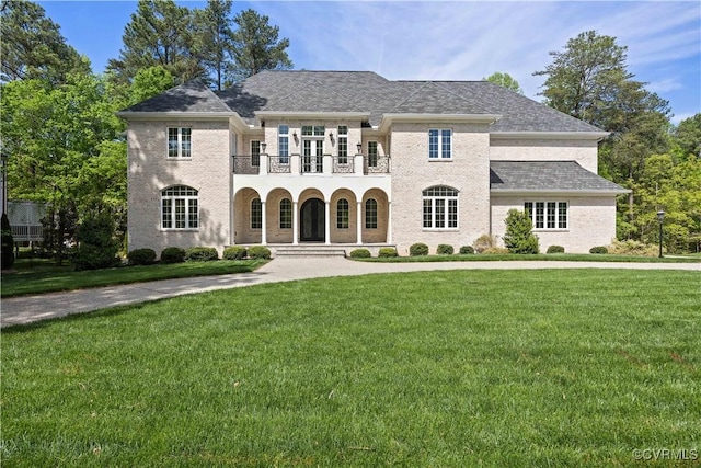view of front of property with a porch, a balcony, and a front yard