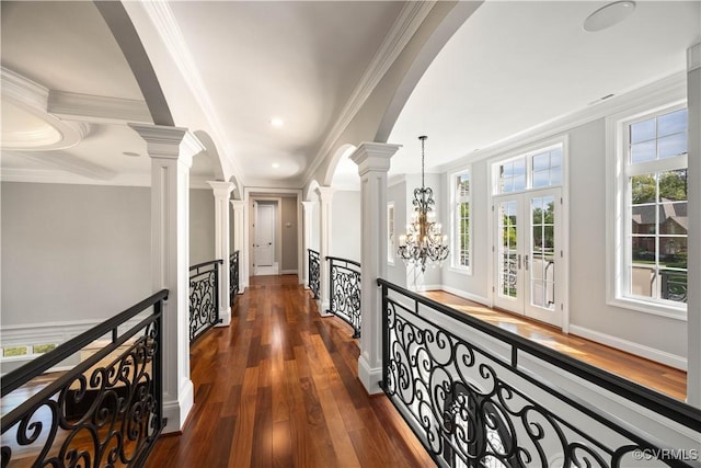 hall featuring ornamental molding, a notable chandelier, an upstairs landing, and dark wood-type flooring