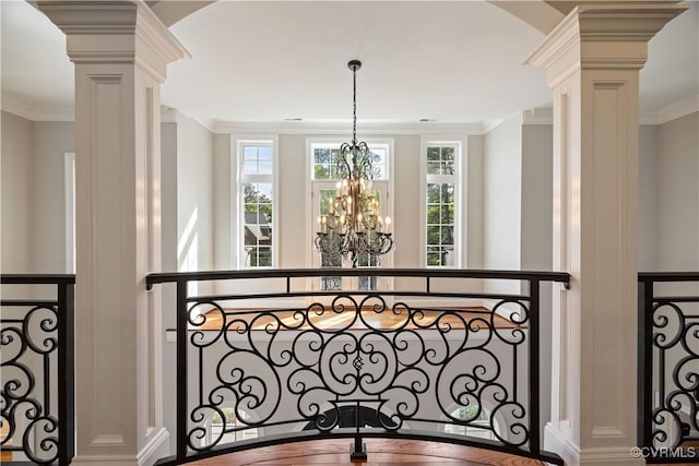 interior space with crown molding, ornate columns, and a chandelier