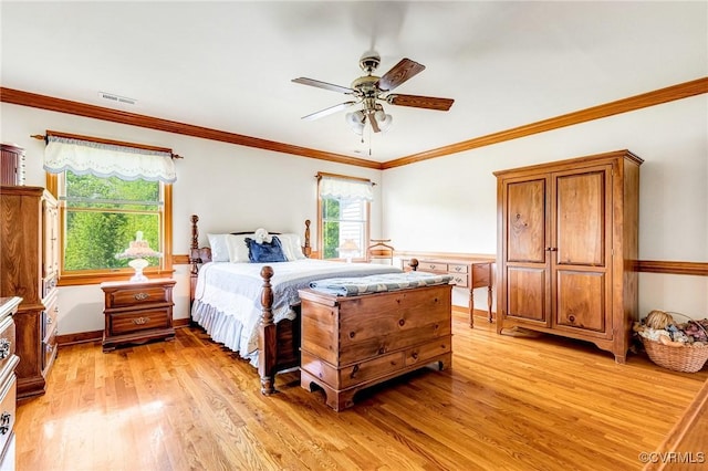 bedroom featuring visible vents, a ceiling fan, light wood finished floors, and crown molding