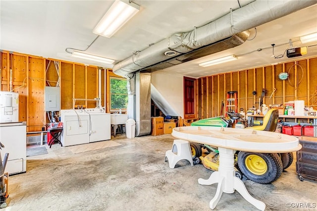 basement featuring separate washer and dryer, a sink, electric panel, and refrigerator