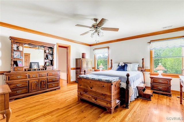 bedroom with a ceiling fan, visible vents, baseboards, ornamental molding, and light wood-style flooring