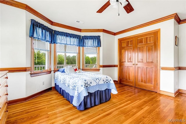 bedroom with visible vents, ornamental molding, light wood-style floors, and baseboards