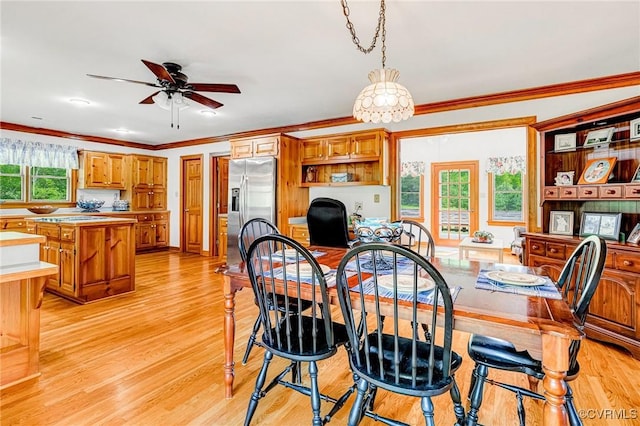 dining area featuring ornamental molding, a ceiling fan, and light wood finished floors