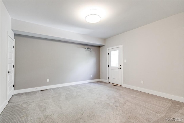 empty room featuring carpet floors, baseboards, and visible vents