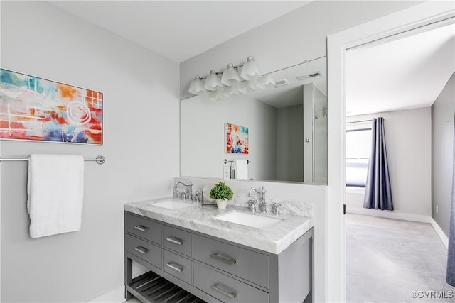 bathroom featuring visible vents, a sink, baseboards, and double vanity