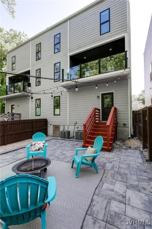 rear view of property with fence, cooling unit, an outdoor fire pit, and a patio area