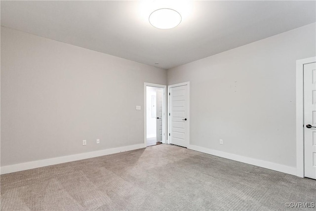 carpeted spare room featuring baseboards