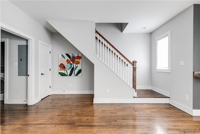 entryway featuring stairs, baseboards, wood finished floors, and electric panel