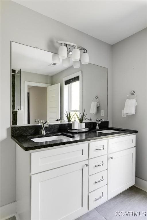 full bathroom featuring a sink, double vanity, and visible vents