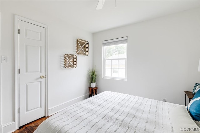 bedroom featuring baseboards, a ceiling fan, and dark wood-style floors