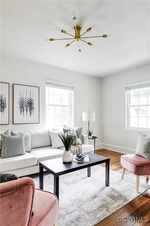 living room featuring baseboards, plenty of natural light, and wood finished floors