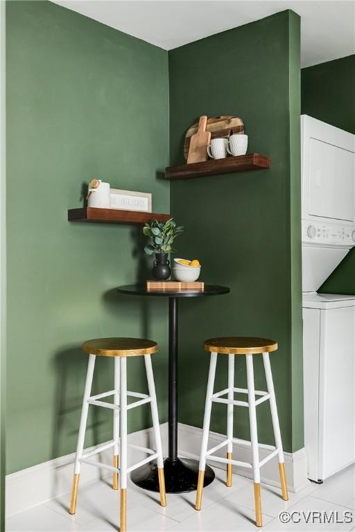dining area with baseboards and stacked washer / dryer