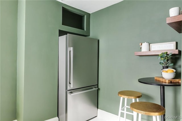 kitchen with freestanding refrigerator and baseboards