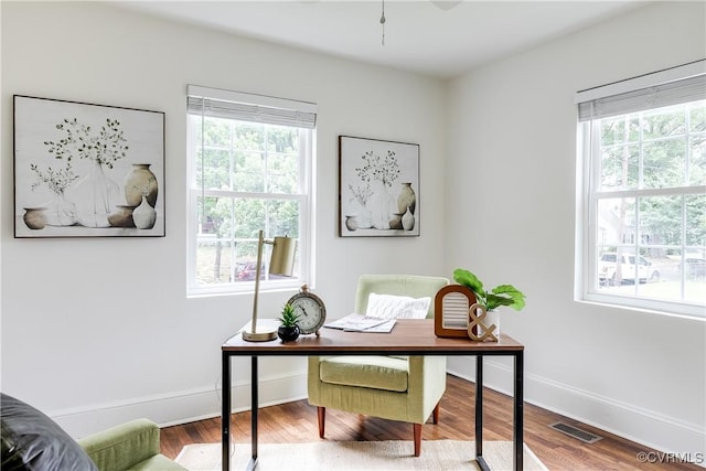 office featuring baseboards, visible vents, plenty of natural light, and wood finished floors