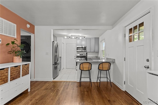 1712 Halifax Ave, Richmond, VA 23224 - kitchen featuring visible vents, wood finished floors, a peninsula, a breakfast bar, and stainless steel appliances