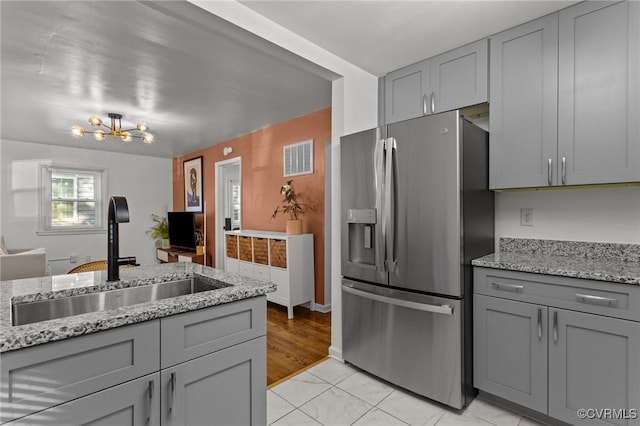 1712 Halifax Ave, Richmond, VA 23224 - kitchen featuring stainless steel refrigerator with ice dispenser, gray cabinetry, a sink, and visible vents