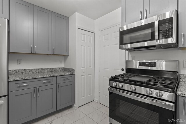 1712 Halifax Ave, Richmond, VA 23224 - kitchen featuring marble finish floor, gray cabinets, appliances with stainless steel finishes, and light stone countertops