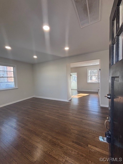 empty room with baseboards, dark wood-type flooring, recessed lighting, and visible vents