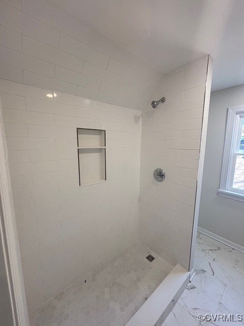 full bathroom with baseboards, tiled shower, and marble finish floor