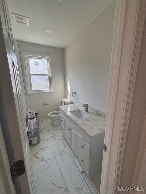 half bath featuring visible vents, vanity, toilet, marble finish floor, and recessed lighting