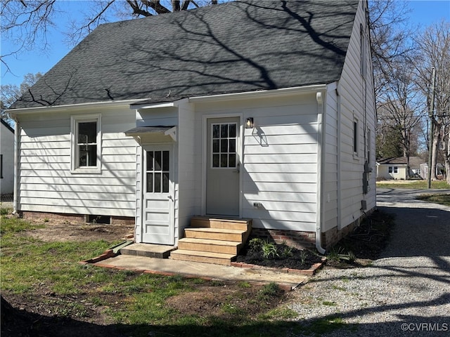 back of house featuring a shingled roof and entry steps