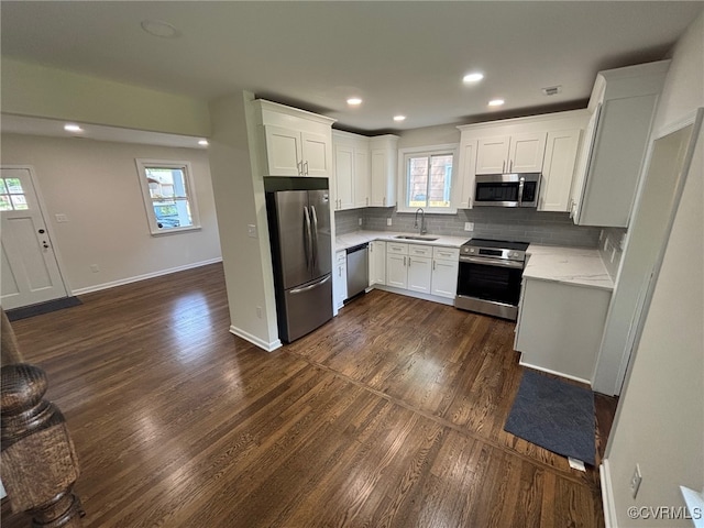 kitchen with plenty of natural light, light countertops, a sink, backsplash, and stainless steel appliances