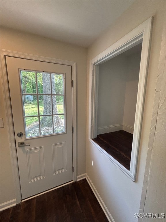 entryway featuring baseboards and dark wood finished floors