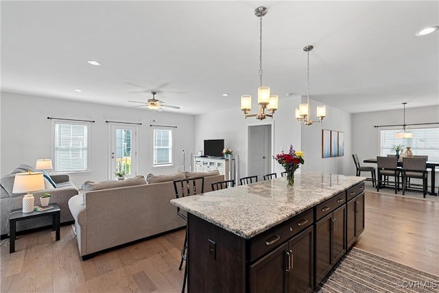 9382 Marne Ct, Mechanicsville, VA 23116 - kitchen featuring light wood-style floors, a ceiling fan, a breakfast bar area, dark brown cabinets, and recessed lighting