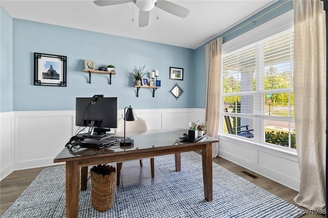 office area with a ceiling fan, wood finished floors, and a decorative wall