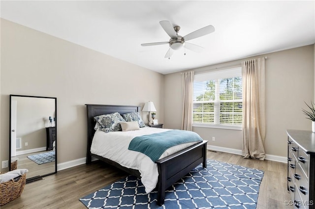 bedroom featuring light wood-style floors, baseboards, ceiling fan, and visible vents