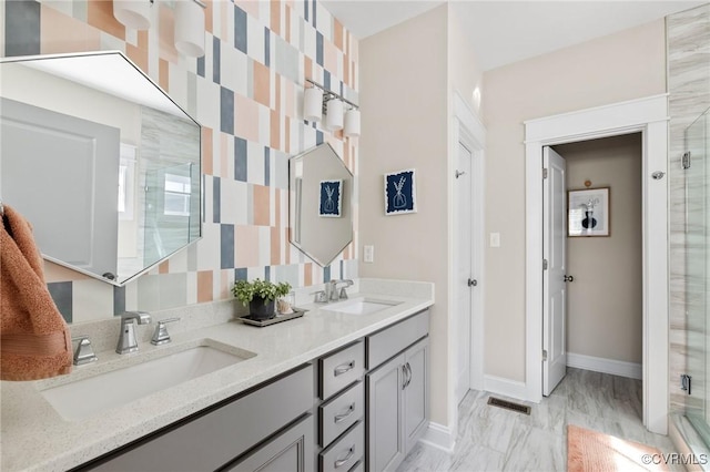 bathroom with baseboards, visible vents, a sink, and a stall shower