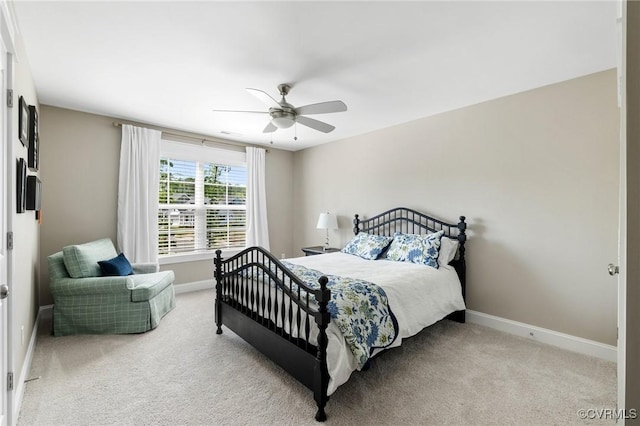 bedroom featuring baseboards, a ceiling fan, and light colored carpet