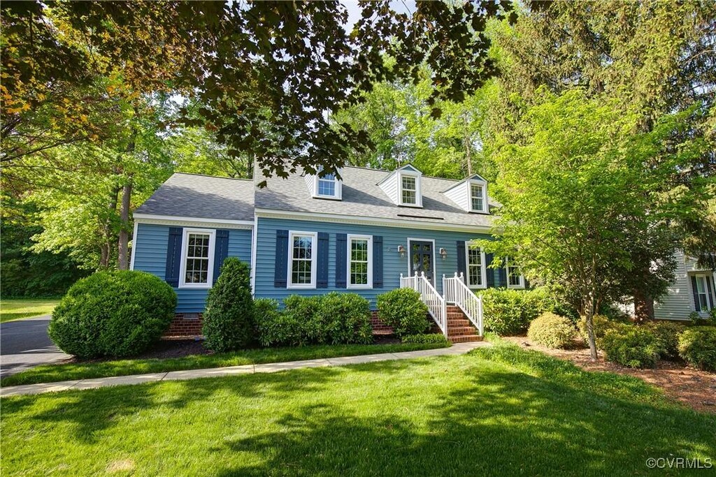 cape cod-style house with a front yard