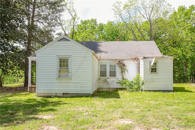 rear view of house featuring a lawn, roof with shingles, and crawl space