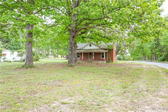 view of front facade featuring a porch, a front lawn, and brick siding