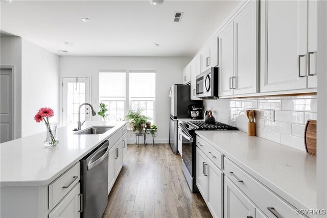 421 Randolph View Dr, Midlothian, VA 23114 - kitchen featuring stainless steel appliances, a kitchen island with sink, tasteful backsplash, and light countertops