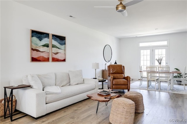 living room featuring ceiling fan, wood finished floors, and visible vents